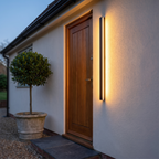 Nero lit beside a front door at dusk