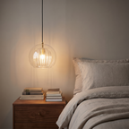 Orbel pendant beside a bed in the evening
